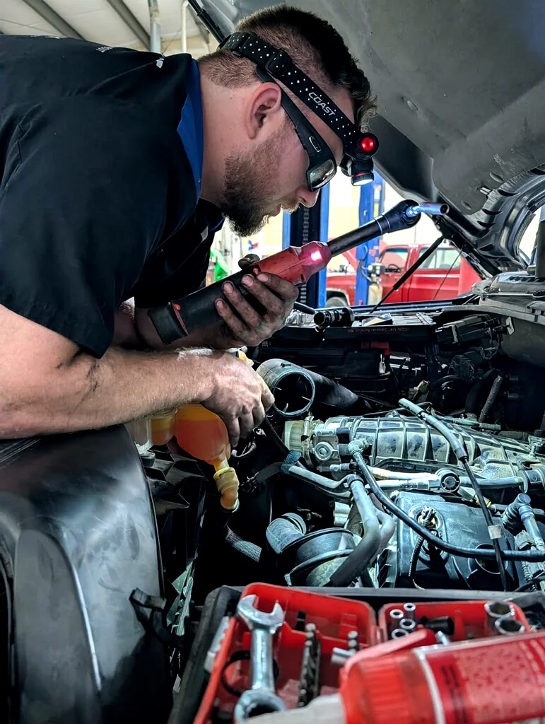 An auto mechanic performing AC and air conditioning repair on a vehicle at The Automotive Shop in Jerome, Idaho